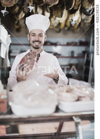 Smiling man assistant showing piece of meat Smiling man assistant showing piece of meat 48619838