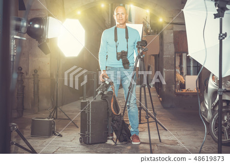 Portrait of cheerful photographer with his camera during photo s 48619873