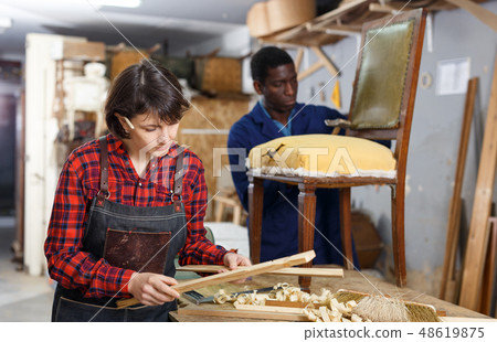 Artisans in process of renewing armchair 48619875