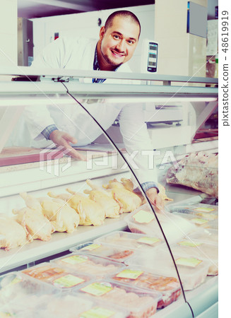 salesman near display with chicken 48619919