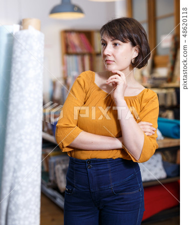 Brunette contemplating about buying in fabric store Brunette contemplating about buying in fabric store 48620118