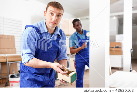 Two male builders working at indoors building site 48620168