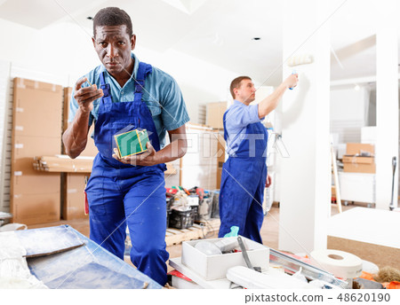 Two male builders working at indoors building site 48620190