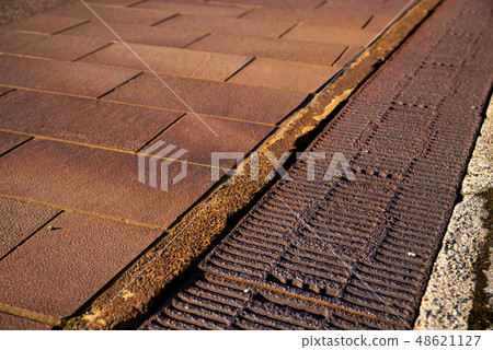 白雪皚皚的鄉村紅色路面和側槽蓋 48621127