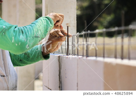 Construction technicians are building brick walls  48625894