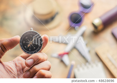 Man holding compass on blurred note Man holding compass on blurred note 48628696