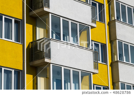 Fragment of brightly colored apartment building with balconies 48628786