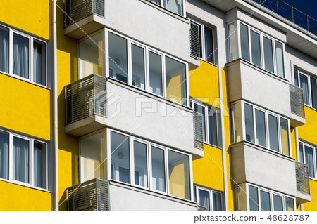 Fragment of brightly colored apartment building with balconies 48628787