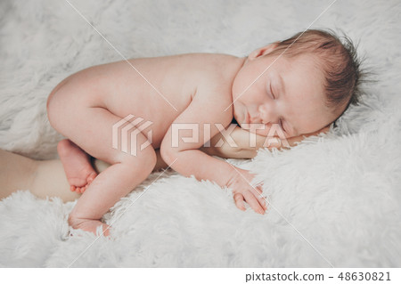 naked newborn baby sleeping curled up in a ball naked newborn baby sleeping curled up in a ball 48630821