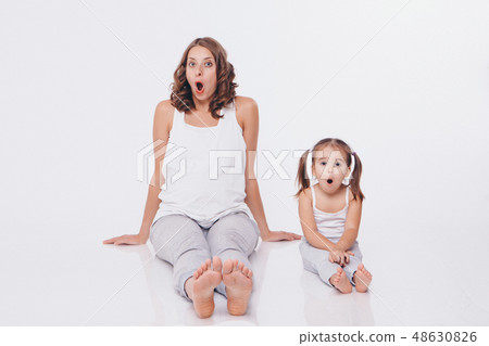 pregnant woman and little girl in tracksuits pregnant woman and little girl in tracksuits 48630826