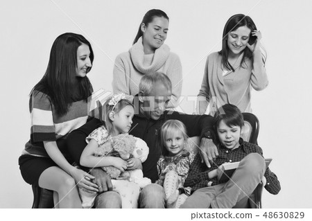adults and children with toys sitting on the couch 48630829