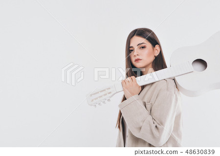 brunette in a light dress holding a white guitar brunette in a light dress holding a white guitar 48630839
