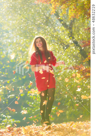 Young woman tossing leaves. Young woman tossing leaves. 48632219