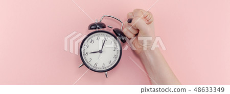 Female hand with alarm clock. Morning concept Female hand with alarm clock. Morning concept 48633349