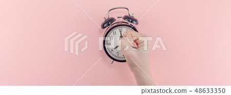 Female hand with alarm clock. Morning concept Female hand with alarm clock. Morning concept 48633350