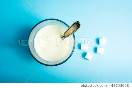glass of milk against blue background glass of milk against blue background 48633638