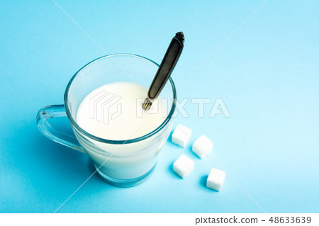 glass of milk against blue background glass of milk against blue background 48633639