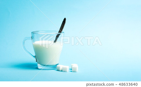 glass of milk against blue background glass of milk against blue background 48633640