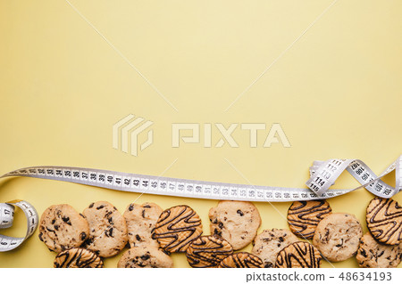 diet. chocolate cookie background and measure tape 48634193