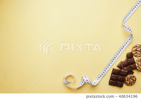 chocolate bar and measure tape. diet and fitness 48634196