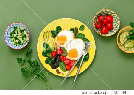 Fried eggs with spinach tomatoes and greens Fried eggs with spinach tomatoes and greens 48634401