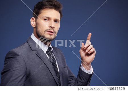 Handsome young business man standing on blue 48635829