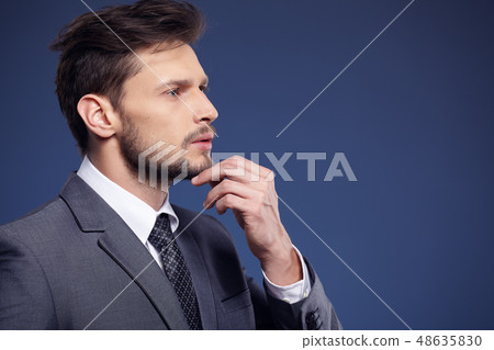 Handsome young business man standing on blue Handsome young business man standing on blue 48635830