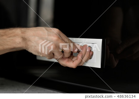 Close-up of an electrician's hand with a Close-up of an electrician's hand with a 48636134