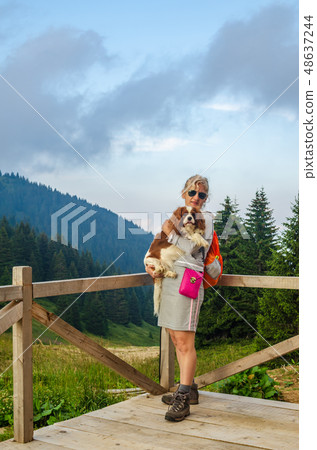 Woman holding dog, in a mountain Woman holding dog, in a mountain 48637244