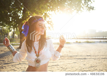 Happy slim tan woman in jeans dancing on the beach 48638106