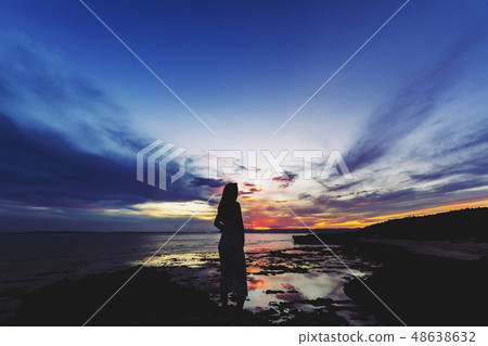 A woman looking at the sunset in Okinawa Kuroshima 48638632