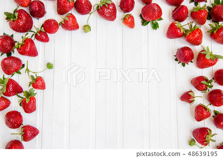 Ripe red strawberries scattered on a white wooden  48639195
