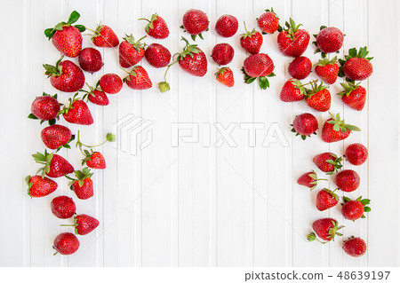 Ripe red strawberries scattered on a white wooden Ripe red strawberries scattered on a white wooden 48639197