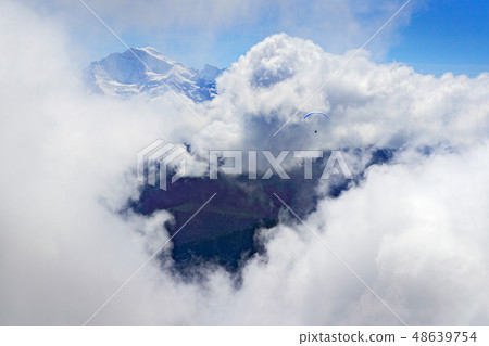 Paragliding flight over the mountain, Switzerland Paragliding flight over the mountain, Switzerland 48639754