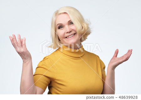 Beautiful older woman in yellow sweater smiling 48639928