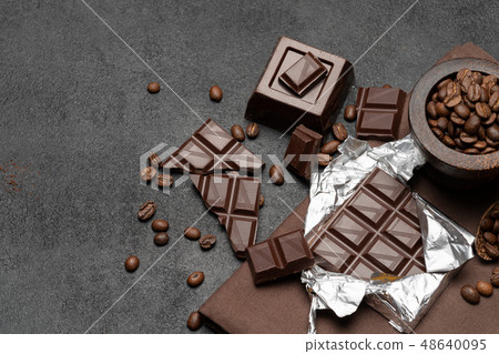 dark organic chocolate and coffee beans on concrete background 48640095