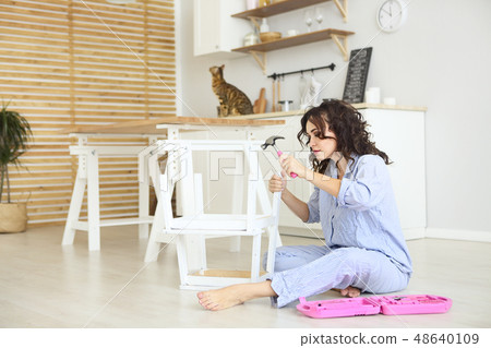Woman moving into new apartment house assembling Woman moving into new apartment house assembling 48640109