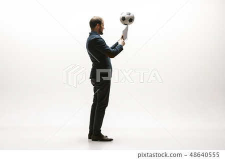 Businessman with football ball in office Businessman with football ball in office 48640555