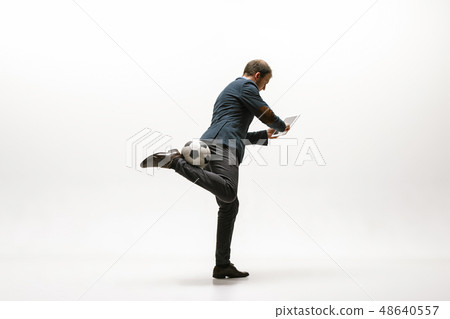 Businessman with football ball in office Businessman with football ball in office 48640557