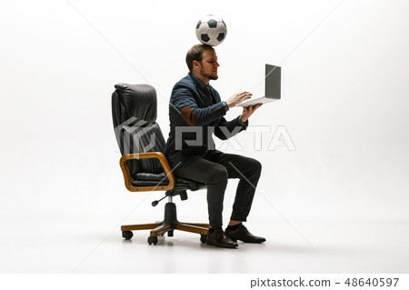 Businessman with football ball in office Businessman with football ball in office 48640597