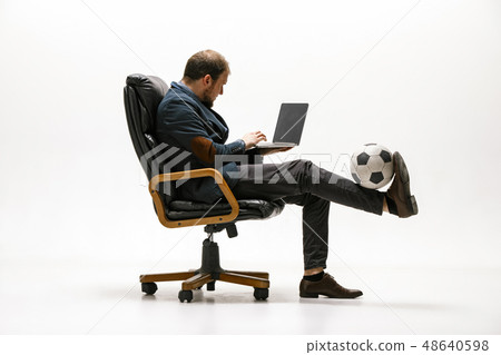 Businessman with football ball in office Businessman with football ball in office 48640598