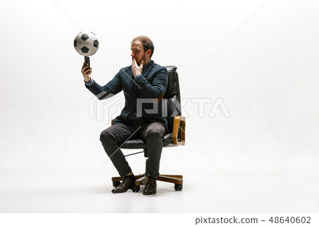 Businessman with football ball in office Businessman with football ball in office 48640602