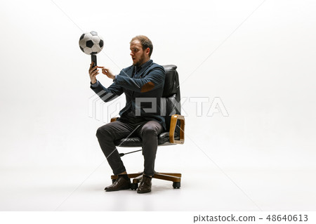 Businessman with football ball in office Businessman with football ball in office 48640613