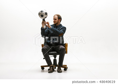 Businessman with football ball in office Businessman with football ball in office 48640619