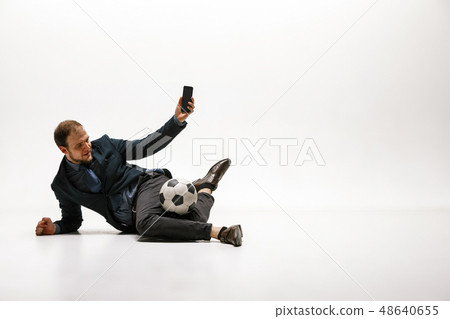 Businessman with football ball in office Businessman with football ball in office 48640655