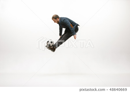 Businessman with football ball in office Businessman with football ball in office 48640669
