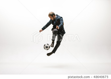 Businessman with football ball in office Businessman with football ball in office 48640673