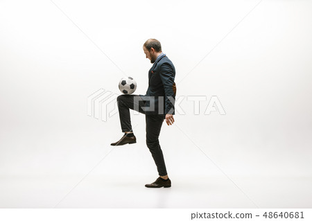 Businessman with football ball in office Businessman with football ball in office 48640681