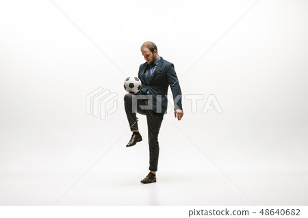 Businessman with football ball in office Businessman with football ball in office 48640682