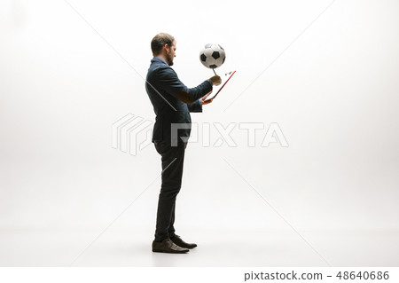 Businessman with football ball in office Businessman with football ball in office 48640686